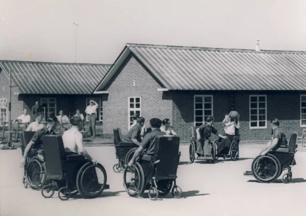 b&W photo of people in wheelchairs playing with a ball