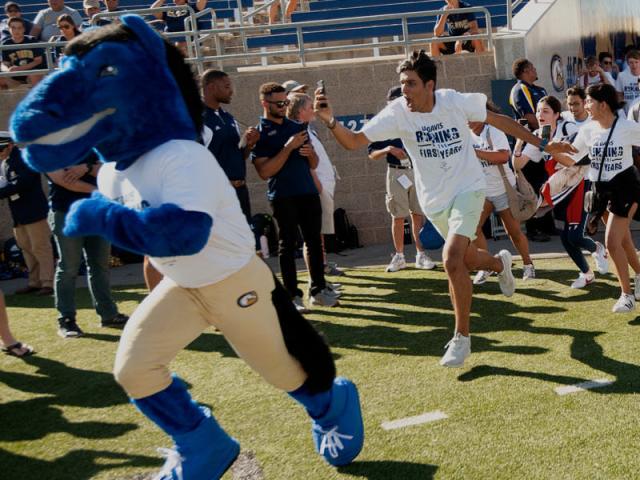 UC Davis Mascot Gunrock leads a group of first-years out onto the football team at halftime in a traditional event called the "Running of the First-years"
