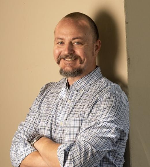 a smiling man with crossed arms
