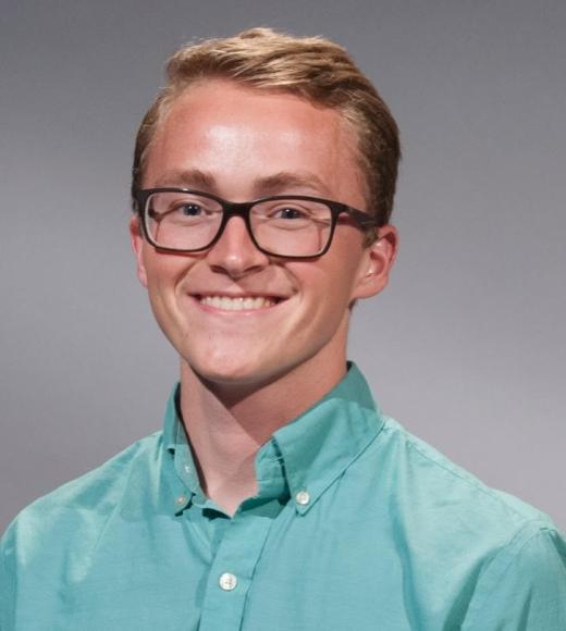 Headshot photograph of Patrick Wade wearing glasses