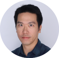 Circular headshot of man with short black hair, blue shirt, neutral expression