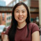 Headshot of Tina Law in a burgundy t-shirt and urban background.