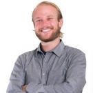 Headshot of Michael Middleton smiling with his arms crossed in a gray button up shirt
